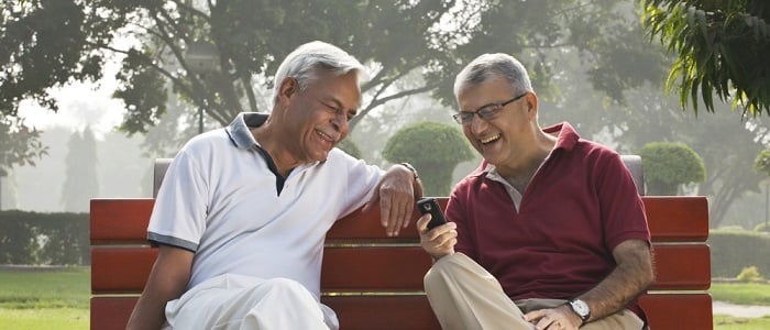 Two men on a bench discussing luxery retirement villages