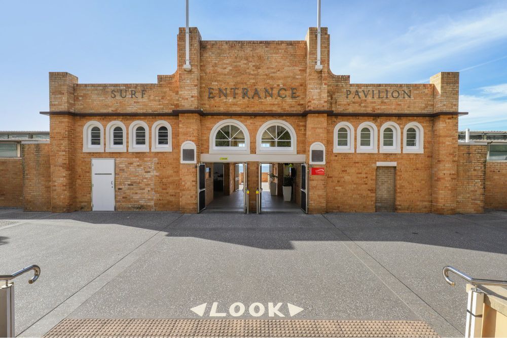 Exterior of the brick Surf Pavilion entrance building on a sunny day.