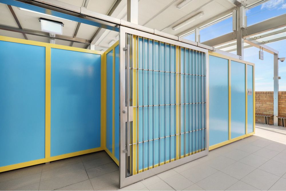 Close-up of modern change rooms with blue panels and a stainless steel door.